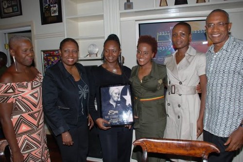Kadine Reynolds with colleagues presenting a framed portrait